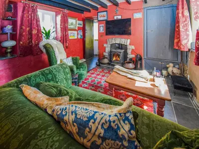 a living room with a couch and a table and a fireplace at Rainbow Cottage in Vickerstown