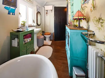 a bathroom with a white tub and a green cabinet at Rainbow Cottage in Vickerstown