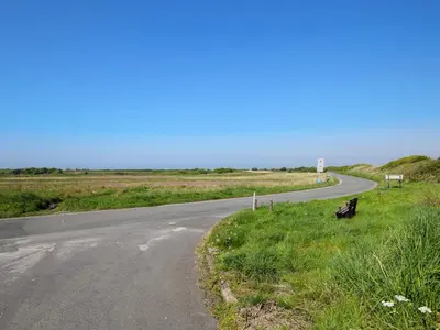 a road with a bench sitting on the side of a road at Rainbow Cottage in Vickerstown
