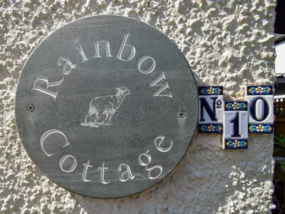 a sign on a wall with a dog on it at Rainbow Cottage in Vickerstown