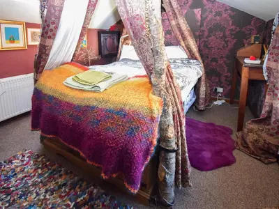 a bedroom with a bed with a canopy at Rainbow Cottage in Vickerstown