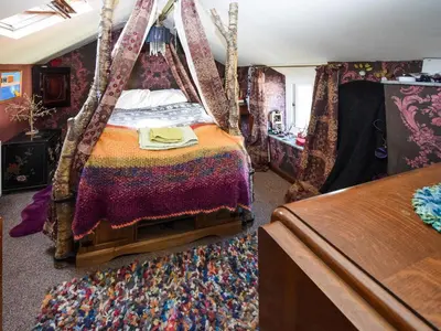 a bedroom with a bed with a canopy at Rainbow Cottage in Vickerstown