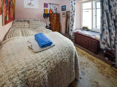 a bedroom with a bed with a blue towel on it at Rainbow Cottage in Vickerstown