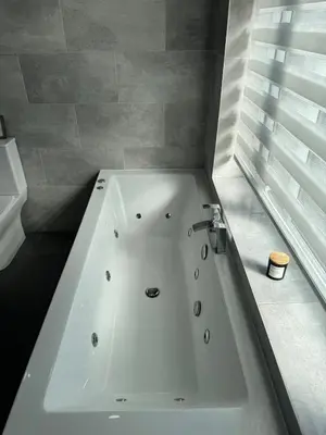 a white bath tub in a bathroom with a window at Beachside Home-Pizza Oven & Bar Close To Beach and Town in Cleveleys