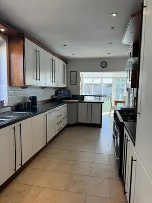 a kitchen with white cabinets and a tile floor at Beachside Home-Pizza Oven & Bar Close To Beach and Town in Cleveleys
