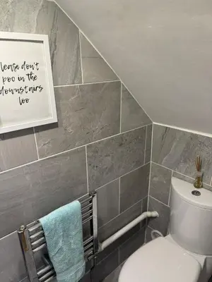a bathroom with a toilet and a picture on the wall at Beachside Home-Pizza Oven & Bar Close To Beach and Town in Cleveleys