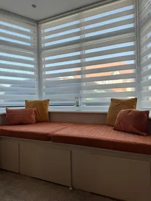 a bench with two pillows sitting in front of a window at Beachside Home-Pizza Oven & Bar Close To Beach and Town in Cleveleys