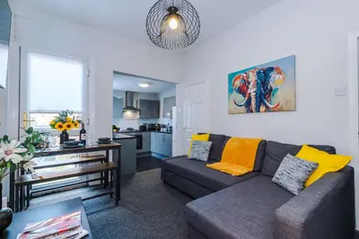 a living room with a couch and a kitchen at Stylish 3-Bed Home in Liverpool by 53 Degrees Property, Ideal Great for Large Groups & Business, Sleeps 8! in Liverpool