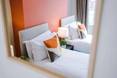 a bedroom with two chairs and a bed with pillows at Stylish 3-Bed Home in Liverpool by 53 Degrees Property, Ideal Great for Large Groups & Business, Sleeps 8! in Liverpool
