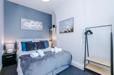 a bedroom with a bed with blue walls at Stylish 3-Bed Home in Liverpool by 53 Degrees Property, Ideal Great for Large Groups & Business, Sleeps 8! in Liverpool