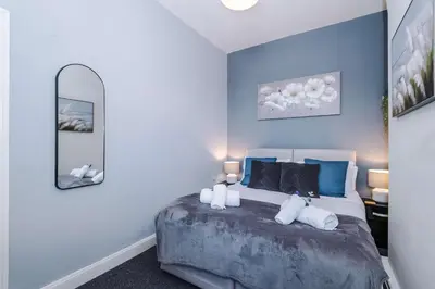 a bedroom with a bed with blue walls and a mirror at Stylish 3-Bed Home in Liverpool by 53 Degrees Property, Ideal Great for Large Groups & Business, Sleeps 8! in Liverpool