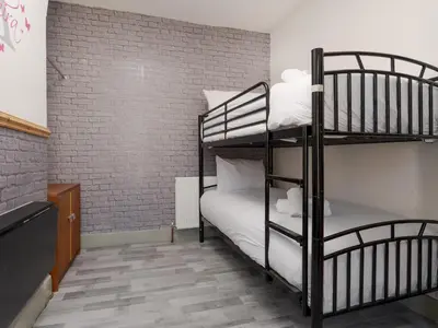 two bunk beds in a room with a brick wall at Liverpool, Anfield 3 Bed Home, Parking & Wifi - Pass the Keys in Liverpool