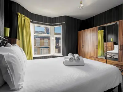 a bedroom with a large white bed with towels on it at Liverpool, Anfield 3 Bed Home, Parking & Wifi - Pass the Keys in Liverpool