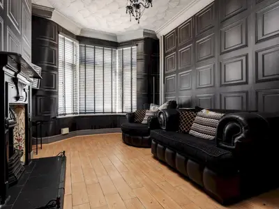 a living room with black leather couches and a fireplace at Liverpool, Anfield 3 Bed Home, Parking & Wifi - Pass the Keys in Liverpool