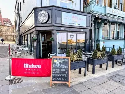 a restaurant with a clock on the front of a building at Top Floor Apt Promenade Sea Views Sleeps 6 Shore Vibes in Morecambe