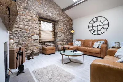 a living room with a stone wall at The Old Paper-shop, WiFi, Sleeps 4 & Pet Friendly in Bolton le Sands