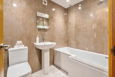 a bathroom with a sink and a toilet and a bath tub at The Old Paper-shop, WiFi, Sleeps 4 & Pet Friendly in Bolton le Sands