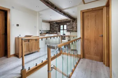 a kitchen with a glass floor and a wooden door at The Old Paper-shop, WiFi, Sleeps 4 & Pet Friendly in Bolton le Sands