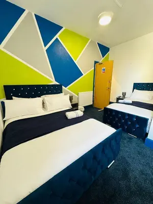 a bedroom with two beds and a colorful wall at Elite Hotel Blackpool in Blackpool