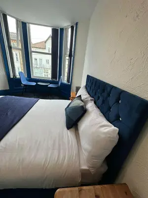 a large bed in a room with two windows at Elite Hotel Blackpool in Blackpool