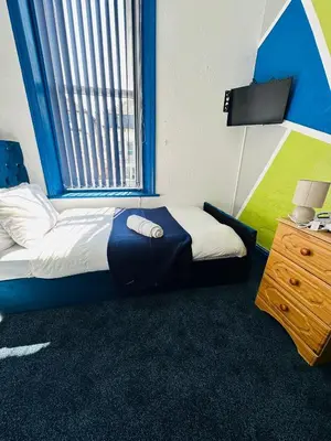 a bedroom with a bed and a window and a desk at Elite Hotel Blackpool in Blackpool