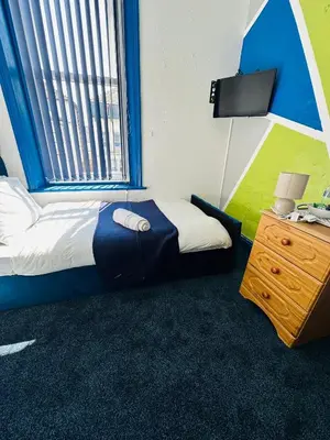 a bedroom with a bed and a window and a desk at Elite Hotel Blackpool in Blackpool