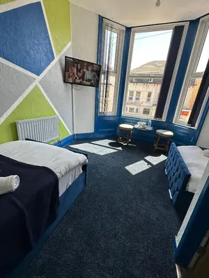 a bedroom with two beds and two windows at Elite Hotel Blackpool in Blackpool