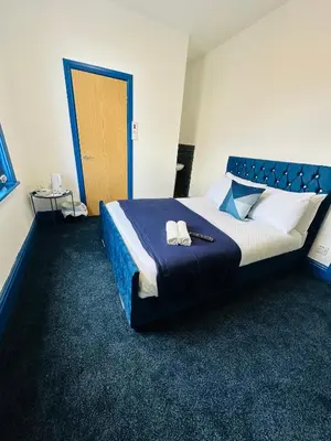 a bedroom with a large bed with two shoes on it at Elite Hotel Blackpool in Blackpool