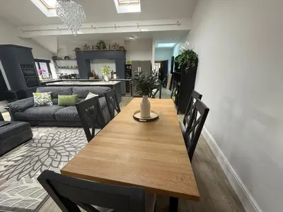 a dining room and living room with a wooden table and chairs at Birkdale Links Lodge in Southport