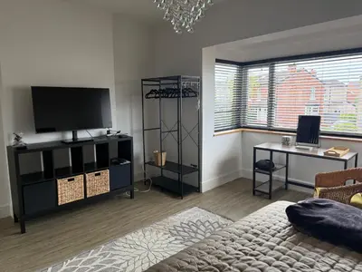 a living room with a flat screen tv and a table at Birkdale Links Lodge in Southport