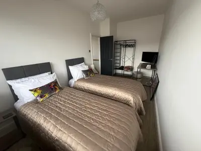 a bedroom with two beds and a desk at Birkdale Links Lodge in Southport