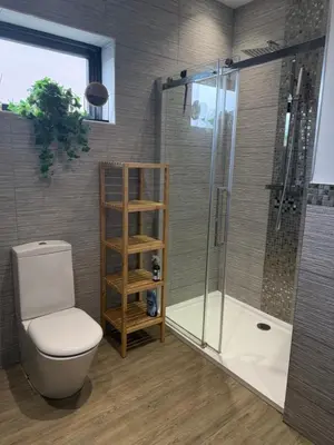 a bathroom with a toilet and a glass shower at Birkdale Links Lodge in Southport