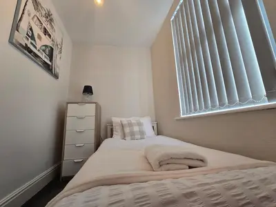 a small bedroom with a bed and a window at Cozy Home in Liverpool in Liverpool