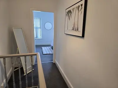 a hallway with a staircase with a picture on the wall at Cozy Home in Liverpool in Liverpool