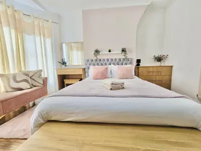 a bedroom with a large bed with pink pillows at Room 4 Shared House in Bootle in Litherland