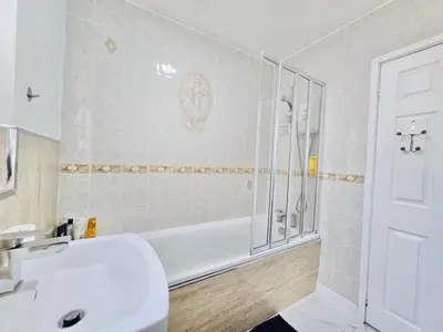 a bathroom with a tub and a sink and a shower at Room 4 Shared House in Bootle in Litherland