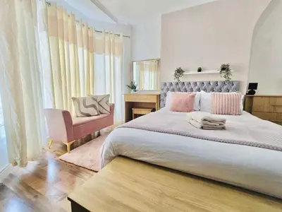 a bedroom with a large bed and a chair at Room 4 Shared House in Bootle in Litherland