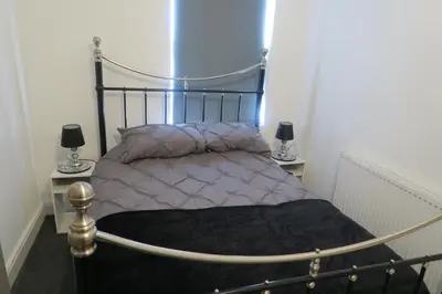 a bed in a room with two lamps on tables at NEW 4 Bed house close to train station and town in Blackpool