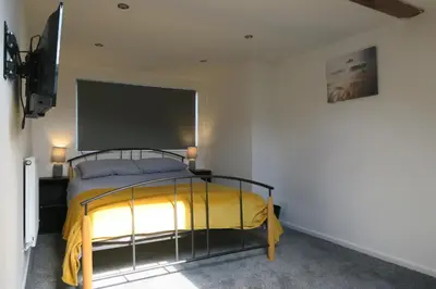 a bedroom with a bed with a yellow blanket at NEW 4 Bed house close to train station and town in Blackpool