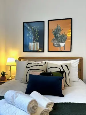 a bedroom with a bed with three pictures on the wall at Wigan 1BR Haven - Perfect for a Relaxing Stay in Wigan