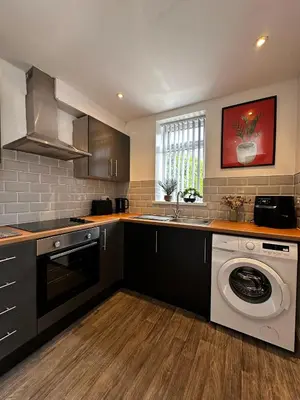 a kitchen with a washing machine and a sink at Wigan 1BR Haven - Perfect for a Relaxing Stay in Wigan