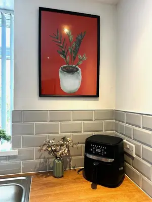 a kitchen with a picture of a plant in a pot at Wigan 1BR Haven - Perfect for a Relaxing Stay in Wigan