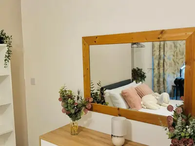 a mirror reflecting a bed in a room at Cozy Home in Bootle in Liverpool
