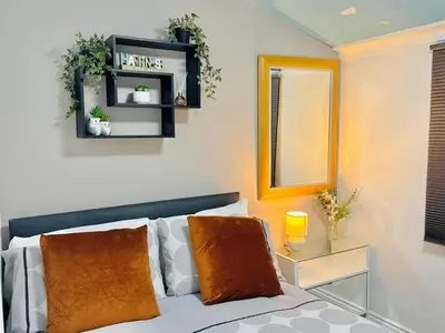 a living room with a bed and a mirror at Cozy Home in Bootle in Liverpool