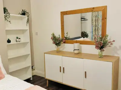 a bedroom with a white dresser with a mirror at Cozy Home in Bootle in Liverpool