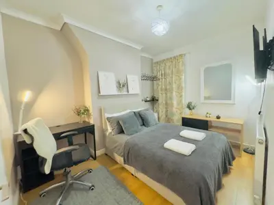 a bedroom with a bed and a desk and a chair at Cozy Home in Bootle in Liverpool