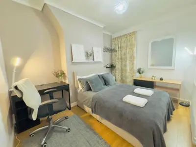 a bedroom with a bed and a desk and a chair at Cozy Home in Bootle in Liverpool