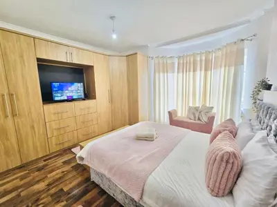 a bedroom with a bed with a television and a chair at Cozy Home in Bootle in Liverpool