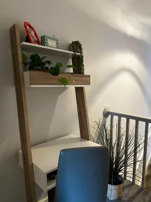 a wooden shelf with plants and a blue chair at Ideal Wigan Base - 1BR for Cosy Stays in Wigan
