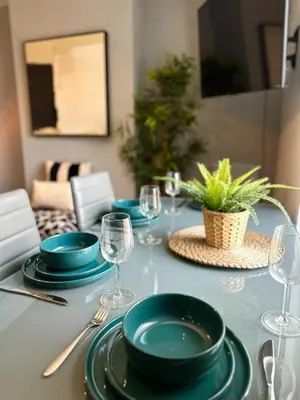 a table with plates and wine glasses on it at Ideal Wigan Base - 1BR for Cosy Stays in Wigan